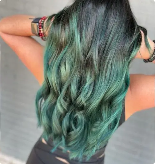 Woman with long turquoise wavy hair.