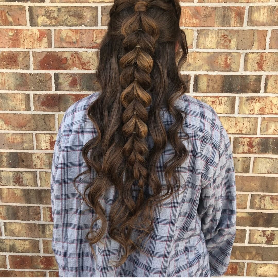 back of woman's hair with long half braid made into heart shapes