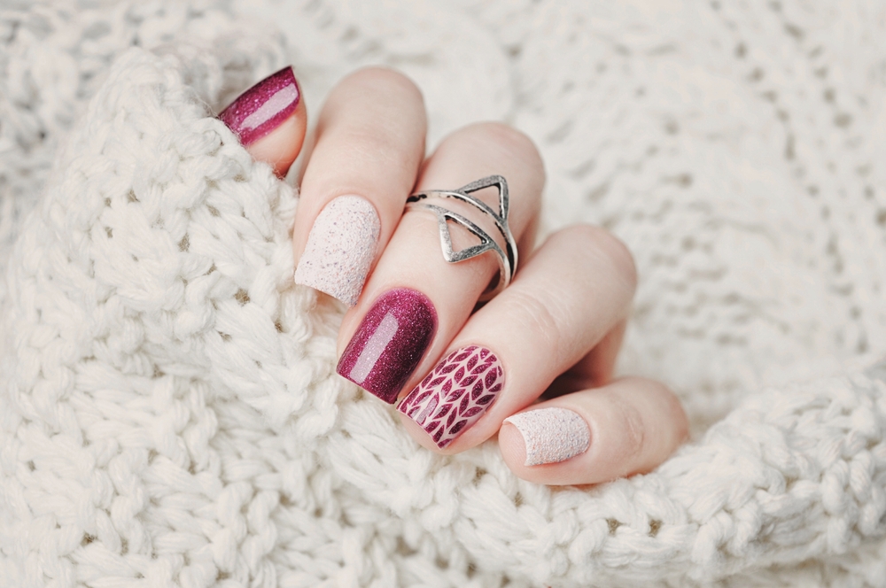 nail art design with middle ring finger holding a sweater