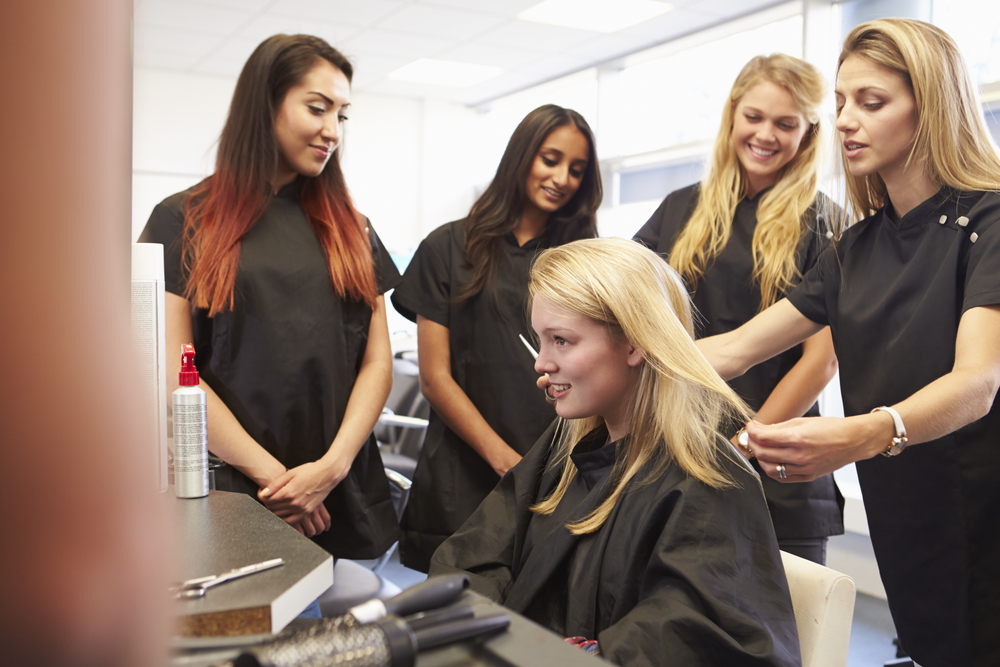 group of cosmetology students gather to watch demonstration