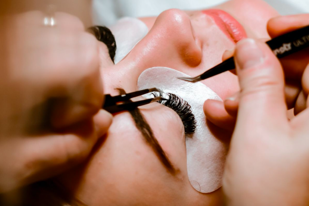 woman getting eyelash extensions in a salon
