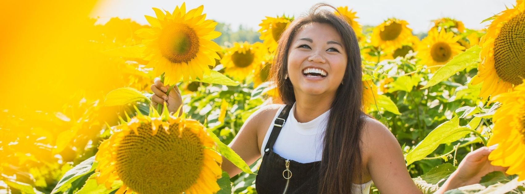 woman laughing in a sunflower field