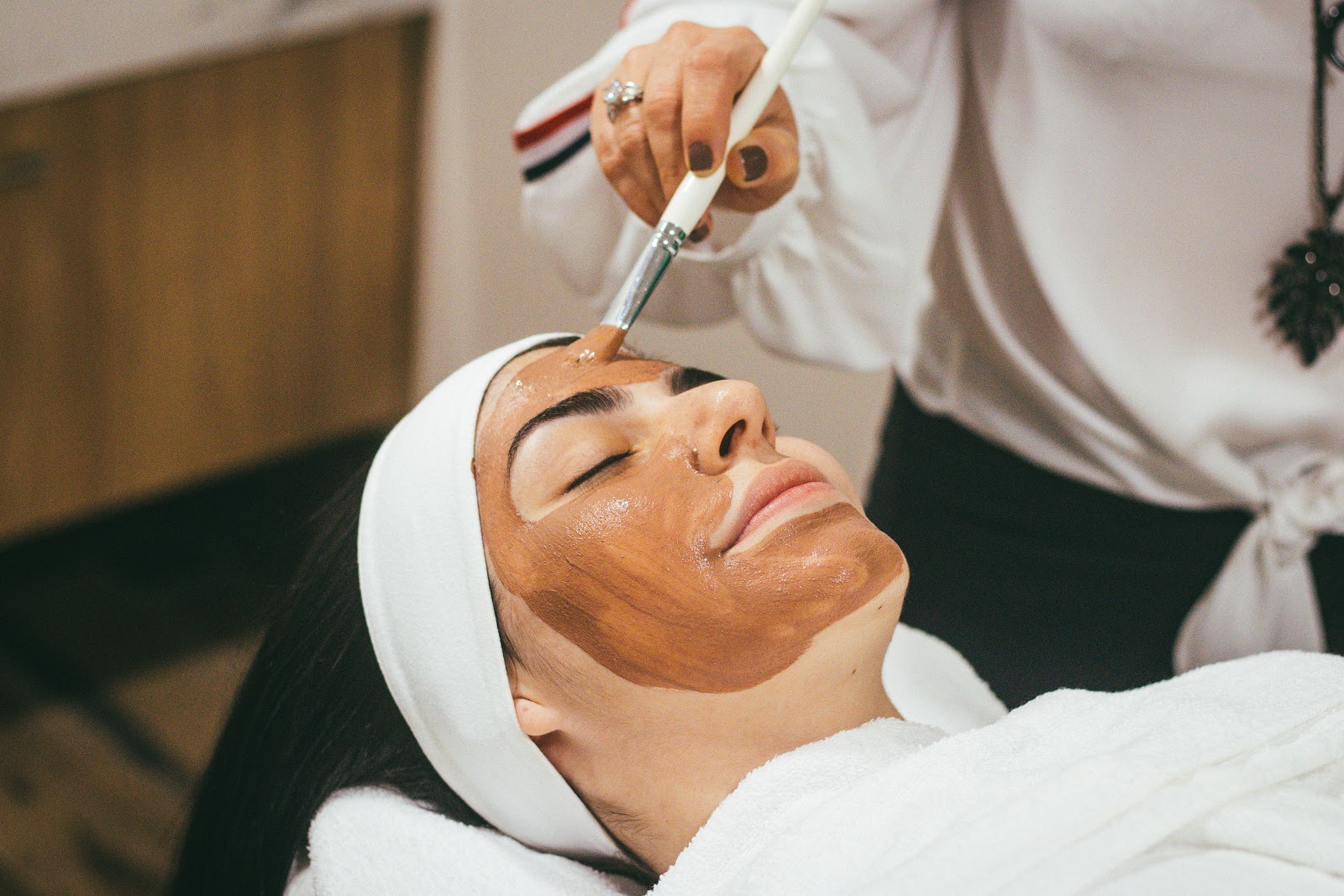 woman getting a facial treatment done at a spa