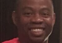 Smiling person wearing a red shirt.