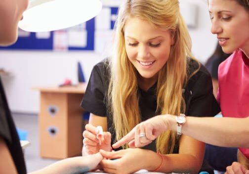 Manicurist instructor teaching nail polish application