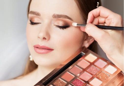 Woman having eyeshadow applied with palette.