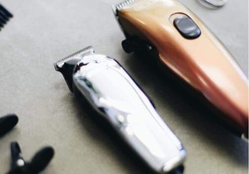 Electric hair clippers and scissors on table.